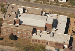 arial shot of a multi-story brick building and roofing