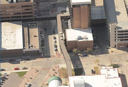 arial shot of multiple buildings. One in center has white roofing