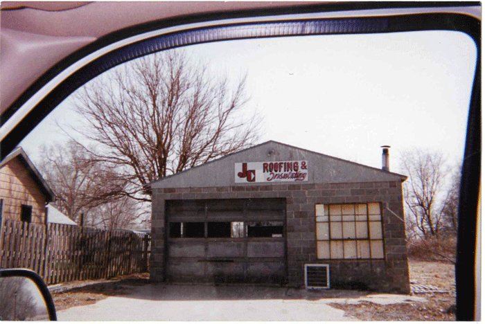 Old JC Roofing shop no longer in use with boarded up windows